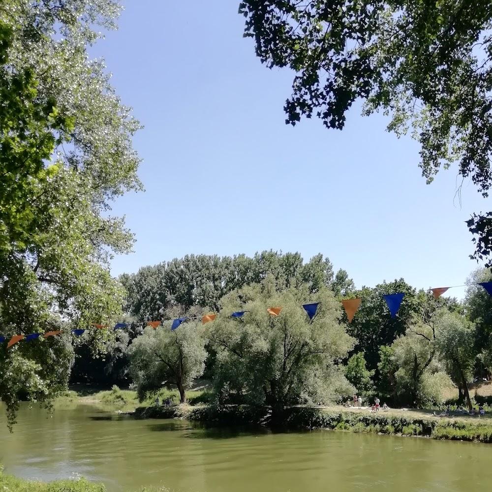 A river, trees, and blue and orange flags.